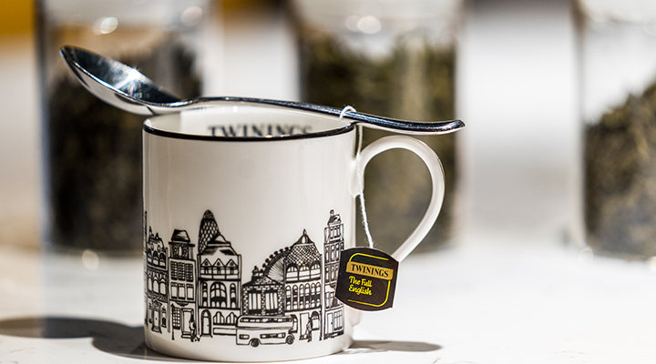A white Twinings mug with a streetscape printed on it in black and white.
