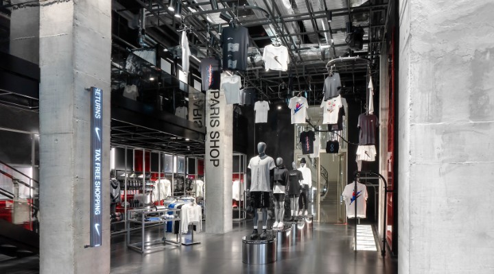 A clothing display at the Nike House of Innovation Paris store with t-shirts hanging from the ceiling.