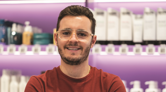 Image of Oz Hair & Beauty COO Guy Nappa taken in a story with purple shelving in the background