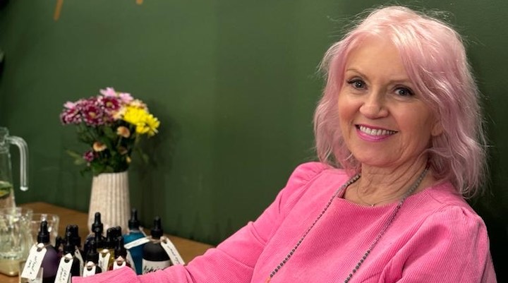 A headshot image of Lush co-founder Rowena Bird sitting against a dark green background.