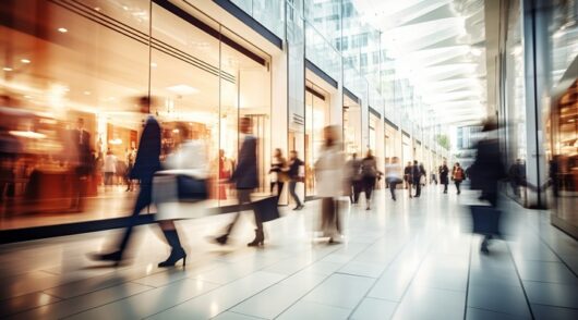 motion blur of people with shopping bags in a busy shopping mall. retail sale and discount.