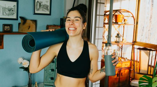 woman in black sports bra holding blue and black kettle