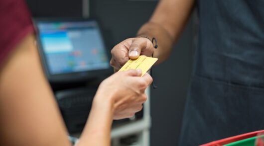 a customer hands credit card to a cashier