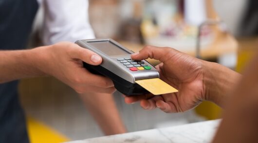 Image of hand using credit card.