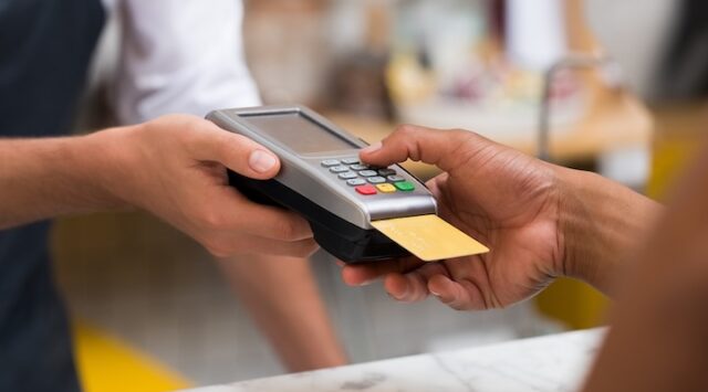 Image of hand using credit card.
