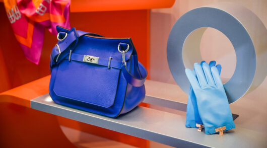 An Hermes window display featuring a bright blue handbag taken at a Milan flagship store.