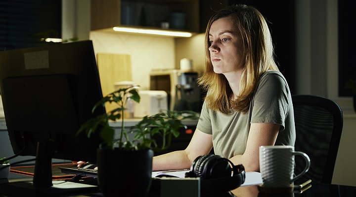a woman working at a computer in a dark room