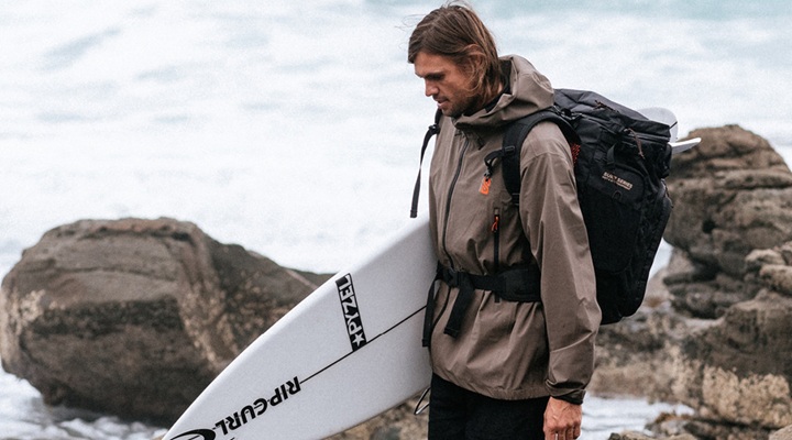 Image of man holding surfboard.
