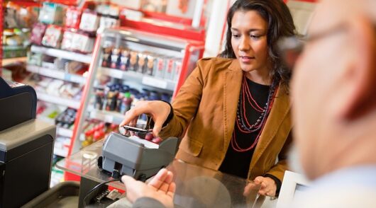 A young woman paying for grocery purchase