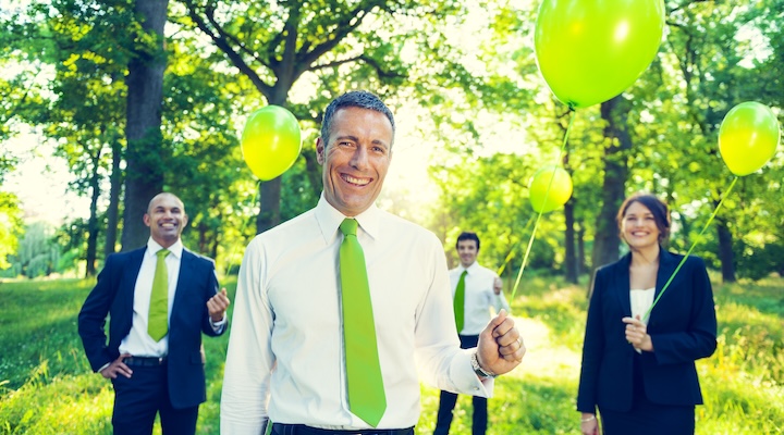 Group of Business People Holding Green Balloons in Forest