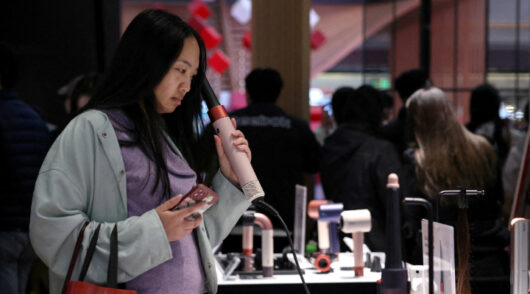 Customers shop for a washing machine at a home appliance mall in Beijing.