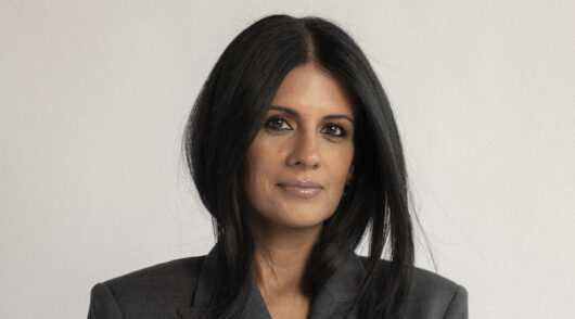 Vestiaire Collective’s North American CEO Samina Virk profile picture against a light gray background.