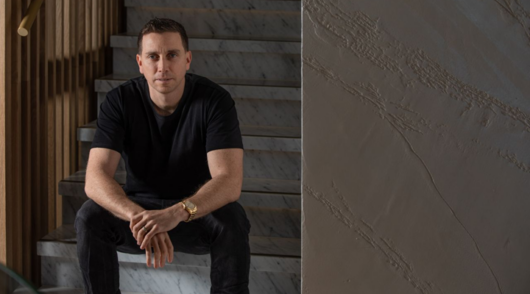 an image of simon beard sitting on the stairs wearing a black t-shirt