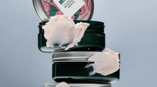 A close-up shot of several containers of hand cream from The Body Shop stacked up.