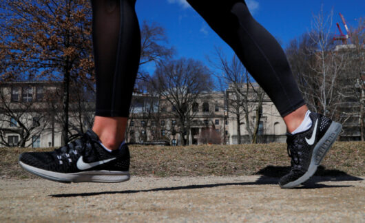 A jogger wearing Nike shoes runs along the Charles River in Cambridge, Massachusetts.
