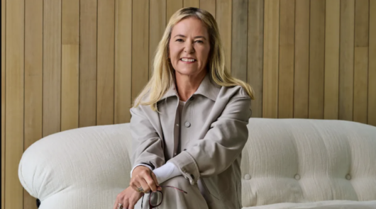 Lululemon’s newly appointed CEO Heidi O'Neill sitting on a white couch.