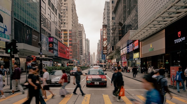 dynamic view of a busy Hong Kong street with pedestrians and taxis during the day