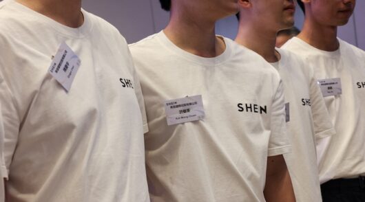 Staff members pose for photos during the listing ceremony for online retailer Shein at the Hong Kong Stock Exchange in Hong Kong