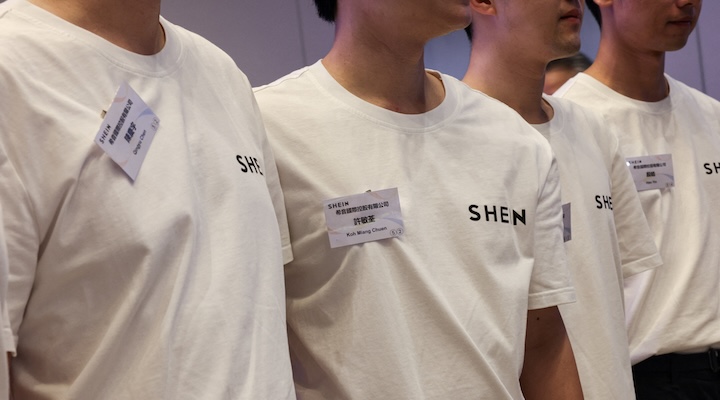 Staff members pose for photos during the listing ceremony for online retailer Shein at the Hong Kong Stock Exchange in Hong Kong