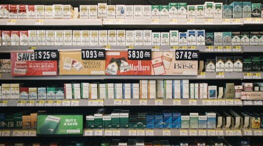 Shelves stocked with various cigarette brands and prices